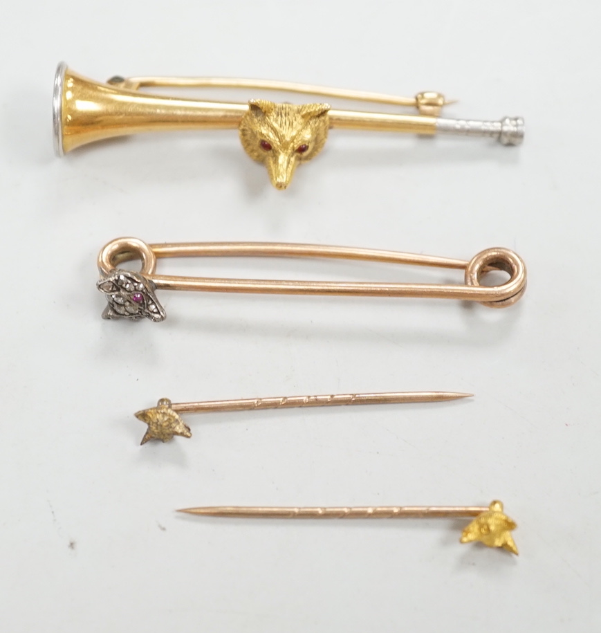 A Victorian yellow metal and diamond cluster set fox head pin, 44mm, two other fox head pins and a 15ct fox head and hunting horn brooch, gross weight 8.5 grams.
